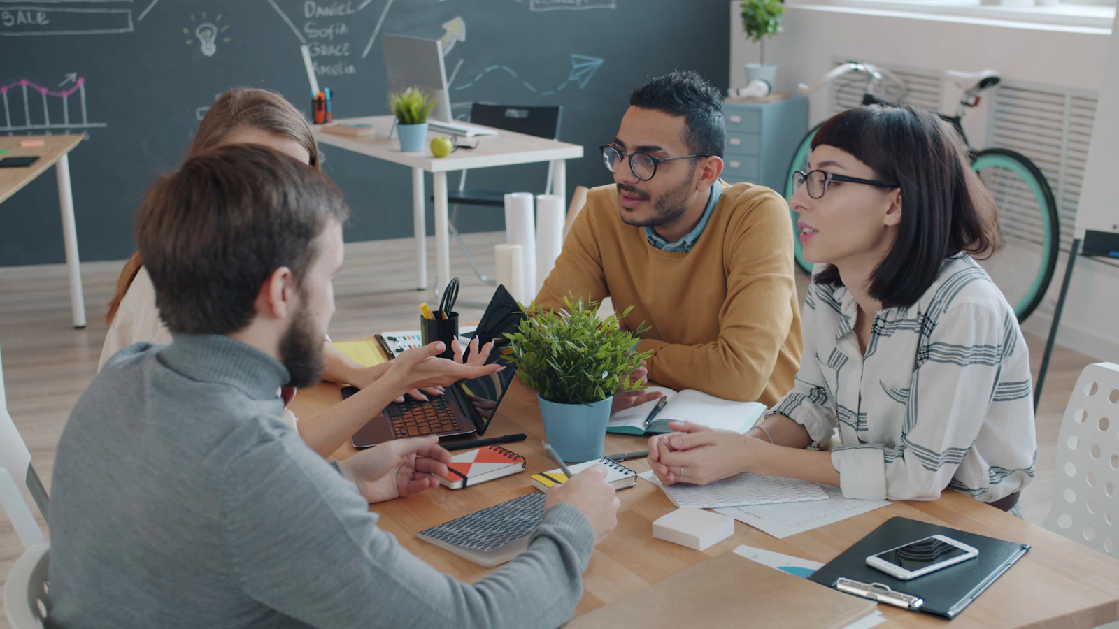 Equipo multidisciplinario de 123GO colaborando alrededor de una mesa de trabajo
