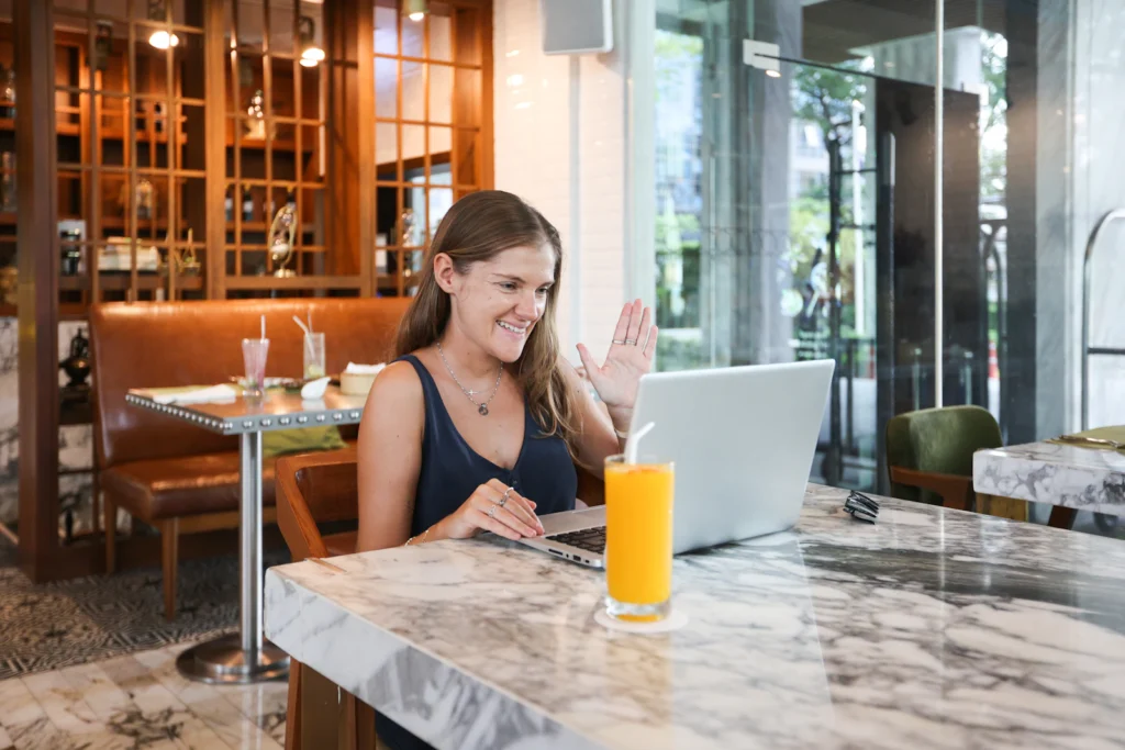 Persona sonriente usando su laptop para buscar oportunidades laborales